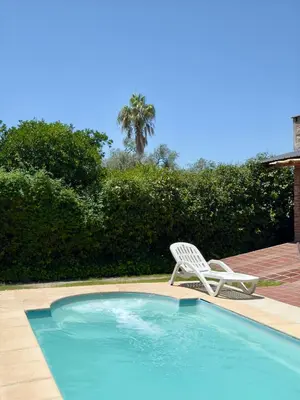 a white chair sitting next to a swimming pool at La Algarroba in Alta Gracia