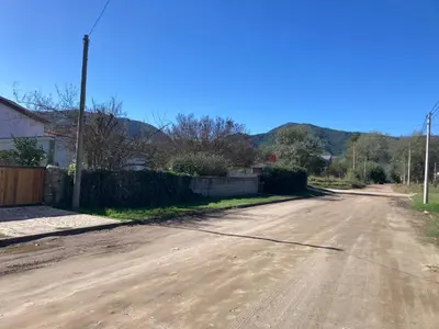an empty road with a fence and a house at cabaña Palmira in Santa Rosa de Calamuchita