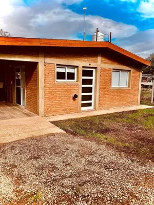 a small brick house with a window and a garage at cabaña Palmira in Santa Rosa de Calamuchita
