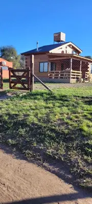a house with a fence in front of a field at Cabaña los ciruelos in Santa Rosa de Calamuchita