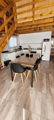 a dining room with a wooden table and chairs at Cabaña los ciruelos in Santa Rosa de Calamuchita