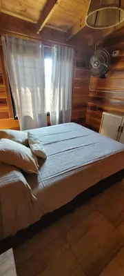 a large bed in a room with a window at Cabaña los ciruelos in Santa Rosa de Calamuchita