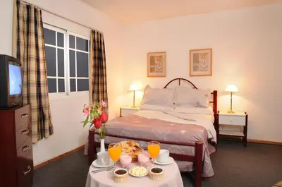 a bedroom with a bed and a table with food on it at Hotel Salerno in Villa Carlos Paz