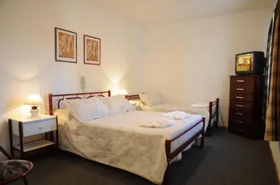 a hotel room with two beds and a television at Hotel Salerno in Villa Carlos Paz