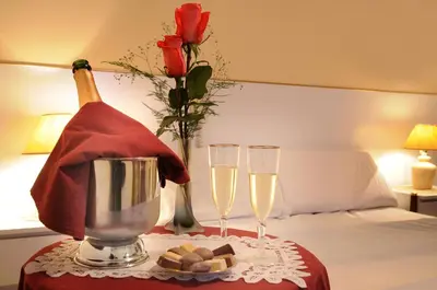 a bed with two glasses of champagne and a bottle of wine at Hotel Salerno in Villa Carlos Paz
