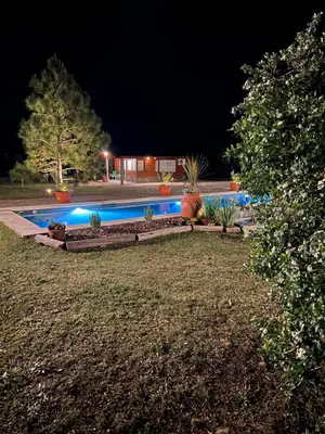 a swimming pool in a yard at night at Rancho la alborada in Los Reartes