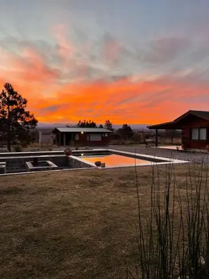 a sunset over a house with a swimming pool at Rancho la alborada in Los Reartes