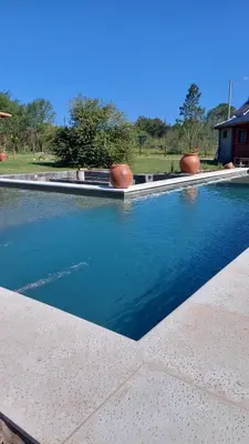 a swimming pool with blue water in a yard at Rancho la alborada in Los Reartes