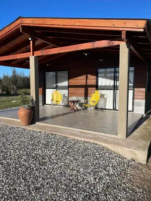 a covered deck with chairs and a table at Rancho la alborada in Los Reartes