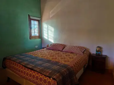 a bedroom with a bed and a window at Alma de Adobe in Merlo