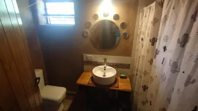 a bathroom with a sink and a toilet and a mirror at Alma de Adobe in Merlo