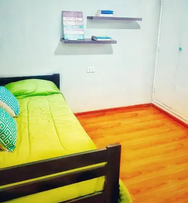 a bedroom with a yellow bed and a wooden floor at Alquiler Temporario Zona Céntrica En Córdoba in Cordoba
