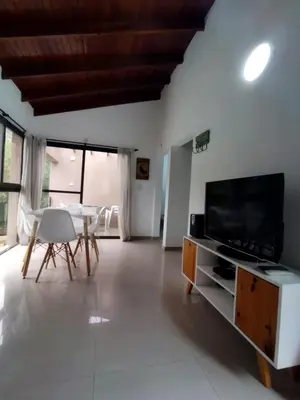 a living room with a television and a table and chairs at FlussHaus VGB in Villa General Belgrano