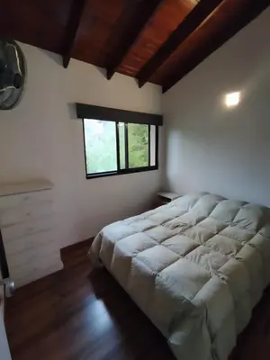 a large bed in a room with a window at FlussHaus VGB in Villa General Belgrano