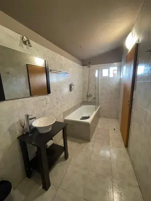 a bathroom with a tub and a sink and a bath tub at POSADA DEL CENTRO in Villa General Belgrano