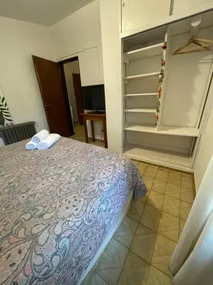 a bedroom with a bed and an open closet at POSADA DEL CENTRO in Villa General Belgrano