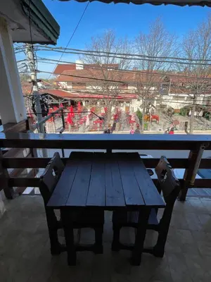 a wooden table with a bench in front of a window at POSADA DEL CENTRO in Villa General Belgrano