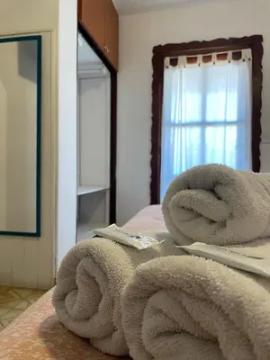 a pile of towels sitting on top of a bed at POSADA DEL CENTRO in Villa General Belgrano