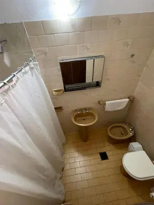 a bathroom with a toilet and a sink at POSADA DEL CENTRO in Villa General Belgrano