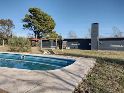 a swimming pool in front of a house at Cabaña La Ilusión in Villa Ciudad Parque