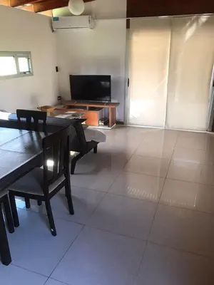 a living room with a table and a television at Cabaña La Ilusión in Villa Ciudad Parque