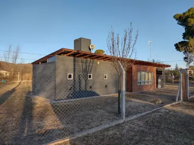 a small house with a fence in front of it at Cabaña La Ilusión in Villa Ciudad Parque