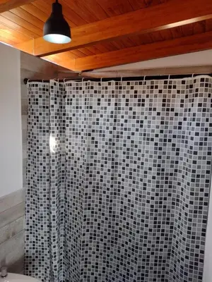 a bathroom with a black and white shower curtain at Cabaña La Ilusión in Villa Ciudad Parque