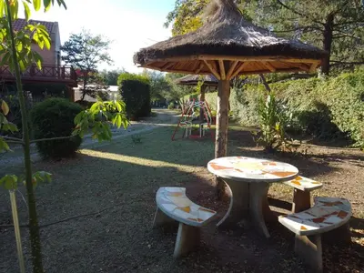 a table and two chairs and a table and umbrella at Cabañas casanostra in Merlo