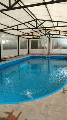 a large swimming pool with a roof at Cabañas casanostra in Merlo