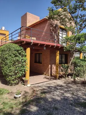 a brick house with a balcony on top of it at Cabañas casanostra in Merlo