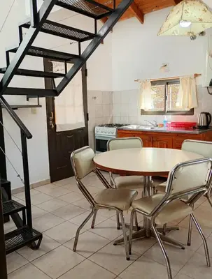 a kitchen with a table and chairs in a room at Cabañas casanostra in Merlo