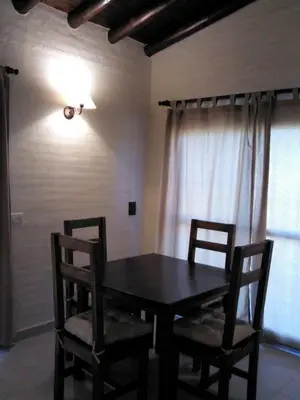 a dining room table with two chairs and a light at Cabanias El Aguaribay in San Javier