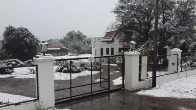 a fence with snow on it in front of a house at Cabanias El Aguaribay in San Javier