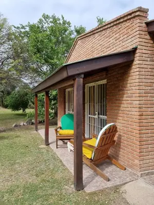a gazebo with a bench and a chair in a yard at Cabanias El Aguaribay in San Javier