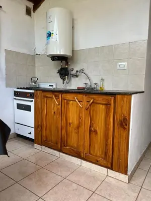 a kitchen with a sink and a stove at Cabañas Los Cedros in Tanti