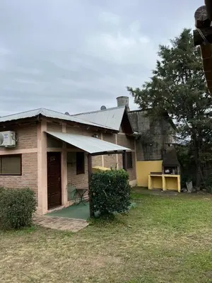 a small house with a porch and a yard at Cabañas Los Cedros in Tanti