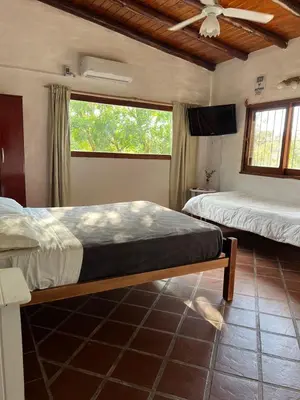 a bedroom with two beds and a ceiling fan at Cabañas Los Cedros in Tanti