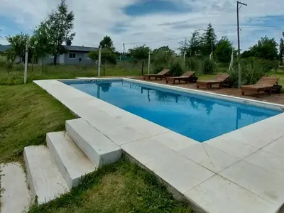 a swimming pool with benches next to at Casa de Valentino in Potrero de Garay