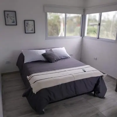 a bedroom with a large bed with two windows at Casa de Valentino in Potrero de Garay