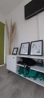 a white shelf with pictures on a white wall at Casa de Valentino in Potrero de Garay