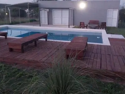 a swimming pool with two benches and a deck with a poolurity at Casa de Valentino in Potrero de Garay