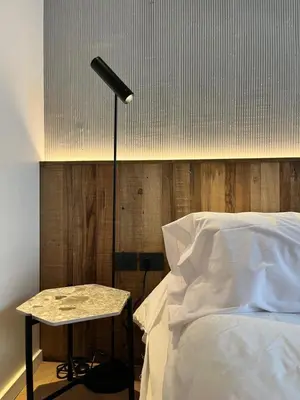 a bed with a lamp and a table next to it at Casa Papagayo in Cordoba