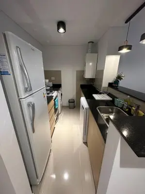 a kitchen with a refrigerator and a sink at Dpto en fontanas del sur, excelentes amenities y muy tranquilo in Cordoba
