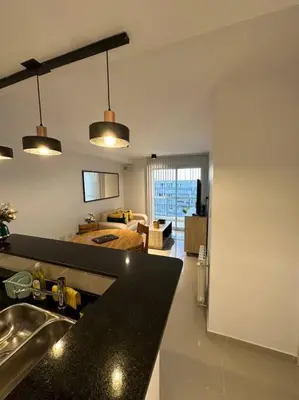 a kitchen with a sink and a living room at Dpto en fontanas del sur, excelentes amenities y muy tranquilo in Cordoba