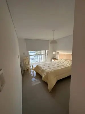 a bedroom with a bed and a table and a window at Dpto en fontanas del sur, excelentes amenities y muy tranquilo in Cordoba
