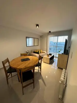 a living room with a table and chairs and a couch at Dpto en fontanas del sur, excelentes amenities y muy tranquilo in Cordoba