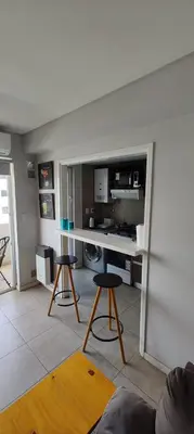 a living room with a desk and two stools at Departamento con seguridad 24hs, gym y pileta! in Cordoba