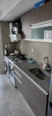 a kitchen with a sink and a stove at Departamento con seguridad 24hs, gym y pileta! in Cordoba