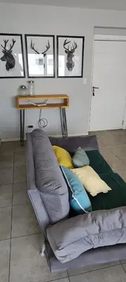 a couch with pillows on it in a room at Departamento con seguridad 24hs, gym y pileta! in Cordoba