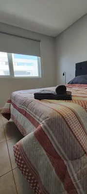 a bedroom with a bed and a window at Departamento con seguridad 24hs, gym y pileta! in Cordoba